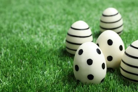 Traditional Easter eggs decorated with black paint on green lawn, space for t Foto stock