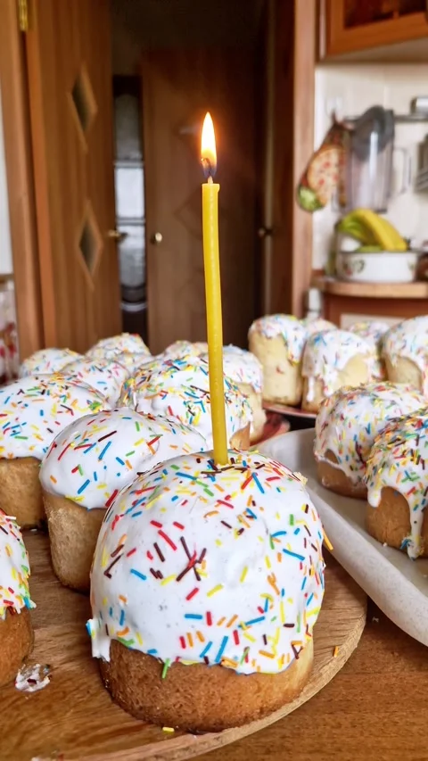 Traditional Easter Kulich Cakes with Lit Yellow Candle in Cozy Kitchen Stock Footage 338999588