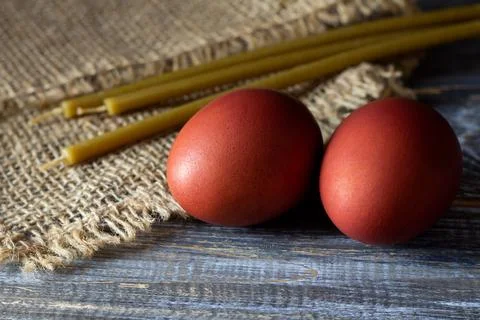 Traditional easter red dyed eggs with beeswax candles on rustic wooden and Stock Photos