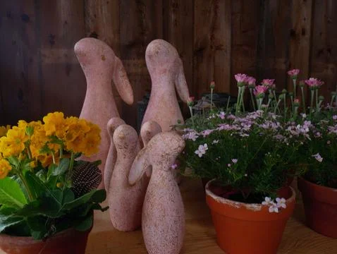 Traditional Easter setting featuring pinkish ceramic bunnies and vibrant po.. 库存照片