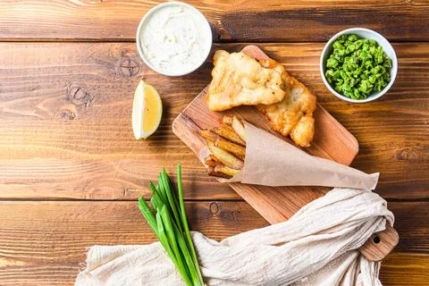 Traditional Fish and chips with mashed peas, tartar sauce inn crumpled paper  Stock Photos