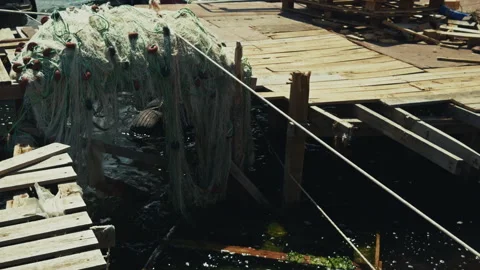 Traditional Fishnet on a Rustic Wooden Dock by the Sea Stock Footage 334153280