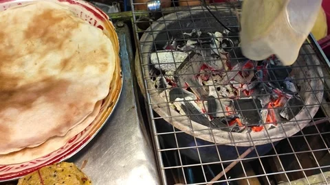 Traditional Flatbread Roasting Over Charcoal Grill at Asian Street Market Stock-Footage 329369982