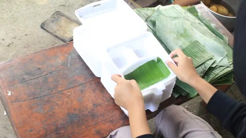 Traditional Food Packaging Using Banana Leaves and Styrofoam Boxes Stock Footage 334647627