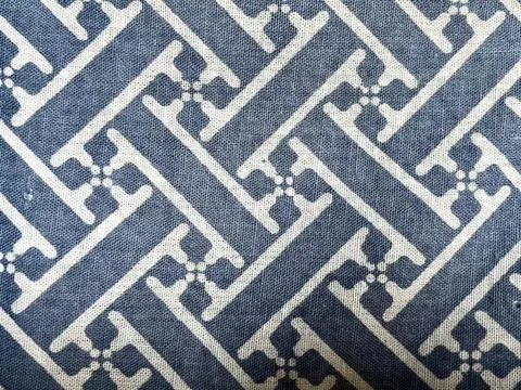 Traditional geometric fretwork pattern printed on blue cotton fabric background Stock Photos