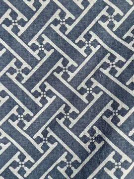 Traditional geometric fretwork pattern printed on blue cotton fabric background Stock Photos