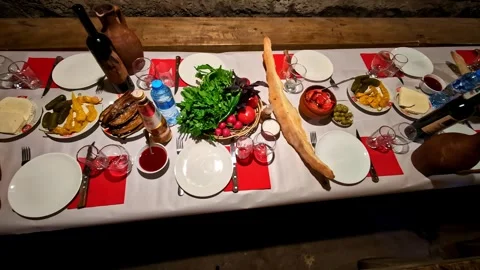 Traditional Georgian Feast Table with Bread, Wine, and Fresh Produce in Simonay Stock Footage 336712605