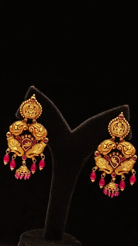 Traditional gold earrings with ruby gemstones captured in smooth rotating motion Stock Footage 346248576