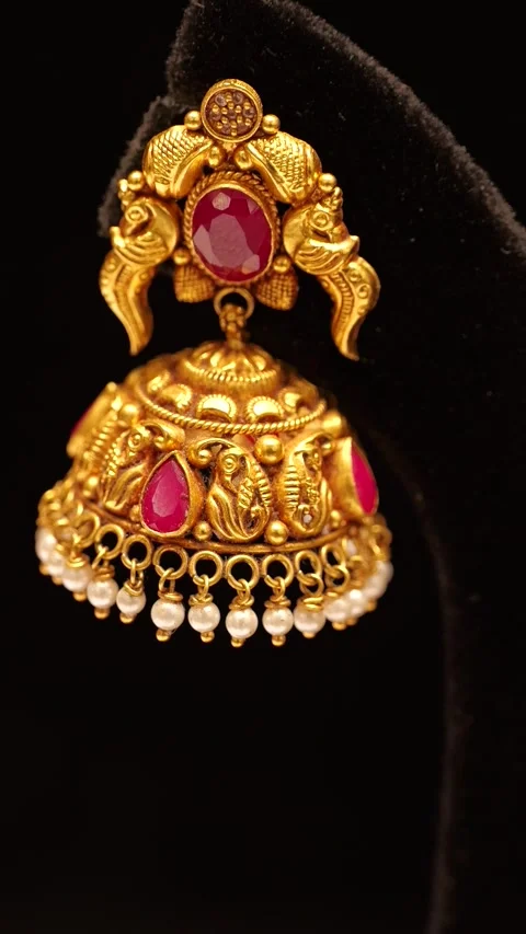 Traditional gold jhumka earring with ruby stones rotating slowly in this beautif Stock Footage 346249126