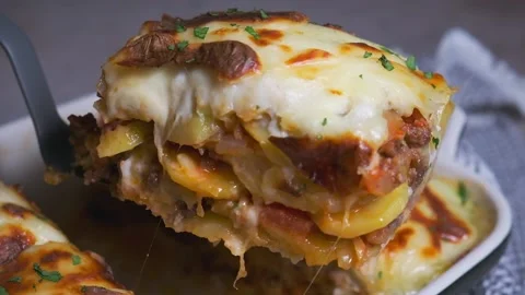 Traditional Greek moussaka - potato and meat casserole with cheese, dark Stock Footage