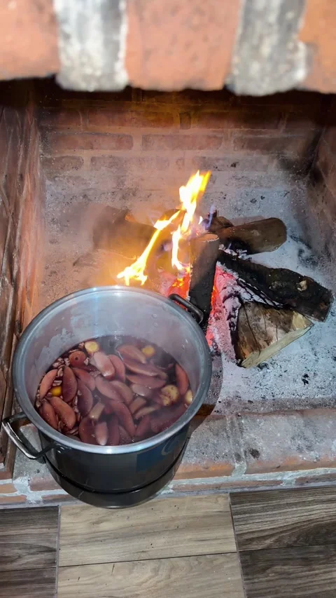 Traditional holiday fruit punch heating in rustic brick fireplace with burning Stock Footage 340863254