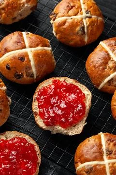Traditional Hot Cross Buns, Easter Sweet Spiced Rolls with Dried Fruit, Straw Foto stock