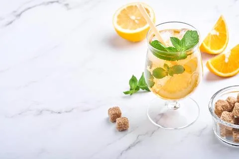 Traditional iced tea with lemon and ice in tall glasses on marble table backg Stock Photos