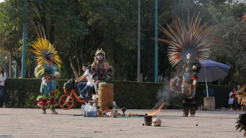 Traditional Indigenous Aztec Fire Dance with Modern Red Bikes Passing Vidéo 104797795