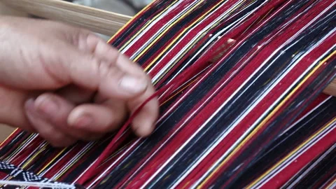 Traditional Karbi handloom weaving with red white and black threads in Assam Stock Footage 339269727