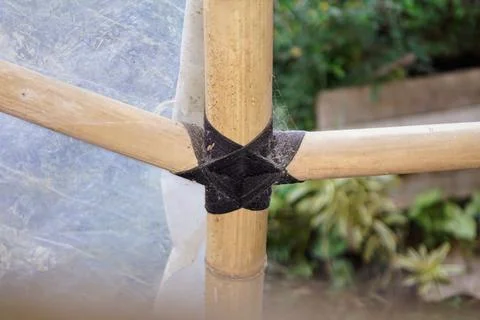 Traditional knotting technique using black rope to connect bamboo framework Stock Photos
