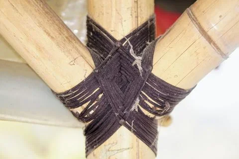 Traditional knotting technique using black rope to connect bamboo framework Stock Photos