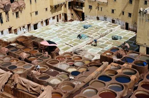 Traditional leather tannery with workers processing hides in a maze of dyeing Stock Photos
