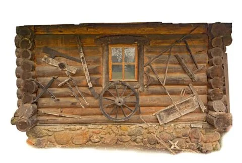 Traditional log house wall with window decorated with rural wooden tools Stock Photos