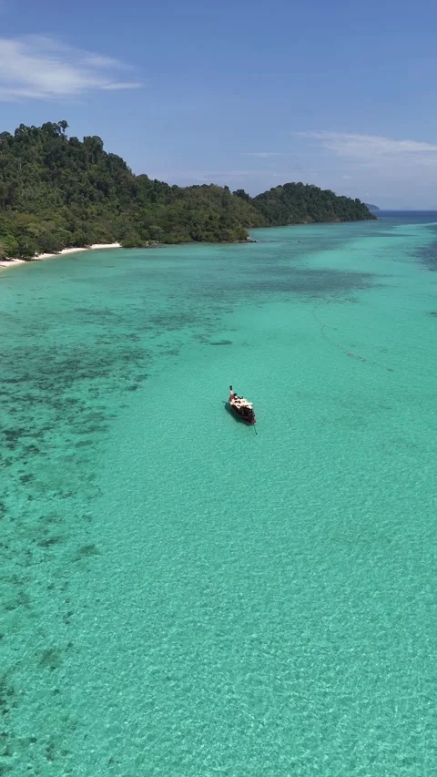 Traditional Long Tail Boat Floating on Turquoise Water Near Tropical Island in Stock Footage 336009102