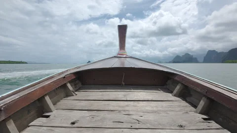 Traditional Long-tail Boat Navigating Coastal Waters Toward Island Peaks Video stock 332281635