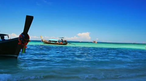 Traditional long tail tourist boat sails away from the tropical beach Stock Footage 59774850