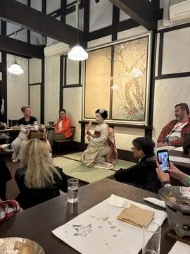 A traditional Maiko (apprentice geisha) in an intimate restaurant setting Фото