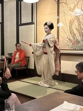 A traditional Maiko (apprentice geisha) performing a dance in a restaurant 库存照片