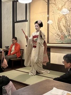 A traditional Maiko (apprentice geisha) performing a dance in a restaurant Fotos Stock