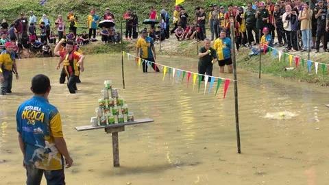 Traditional Malay Tin Throwing Game in Muddy Paddy Fields 動画素材 335268648