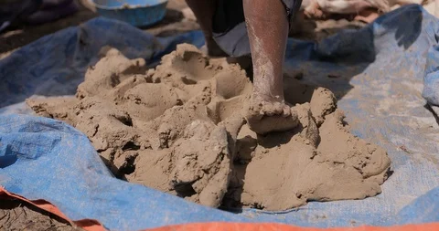 Traditional manual pottery methods craftsman forming clay paste using their legs Видео 109173112