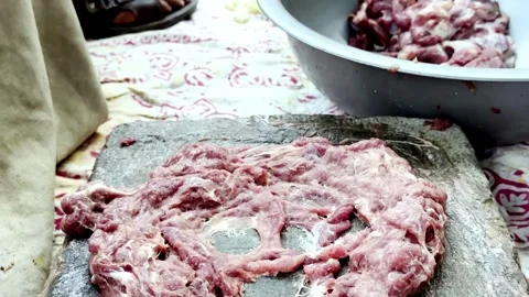 Traditional Meat Preparation by Beating Meat on Stone Stock Footage 339530928