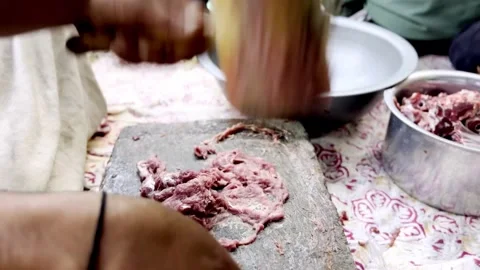 Traditional Meat Preparation by Beating Meat on Stone Stock Footage 339530943