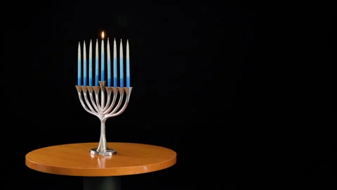 Traditional Menorah initially rotating with self-lighting candles. Stock Footage 323127708