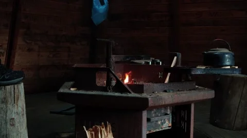 A traditional metal fireplace glows inside a wooden wilderness hut in Lapland Stock Footage 346234742