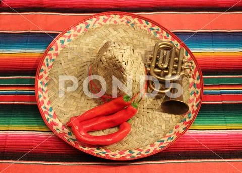 Traditional Mexican fiesta poncho rug in bright colors with sombrero backgro Stock Photos