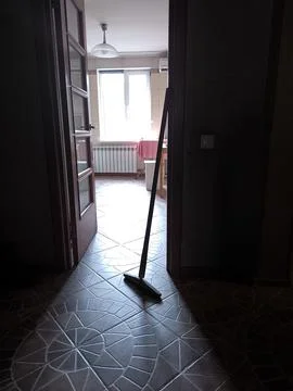 Traditional mop standing in a dark room against bright window light Stockfoto's