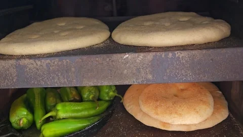 Traditional Moroccan Bread Baking and Roasting Peppers in a Wood-Fired Oven Stock Footage 341898518