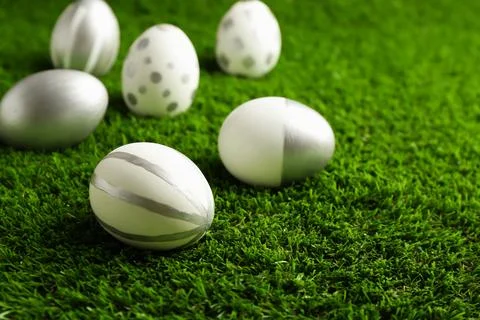 Traditional painted Easter eggs on green lawn, space for text 写真素材