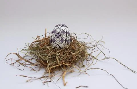 Traditional painted handmade Easter egg on hay Foto stock