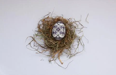 Traditional painted handmade Easter egg on hay Foto stock