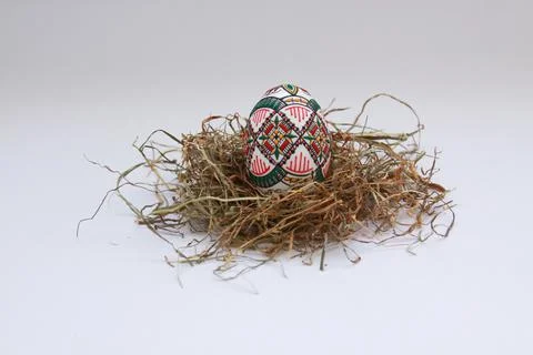 Traditional painted handmade Easter egg on hay Foto stock
