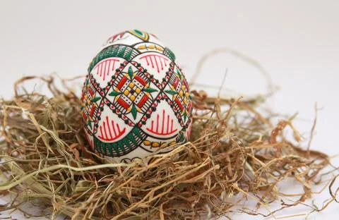 Traditional painted handmade Easter egg on hay Stock Photos