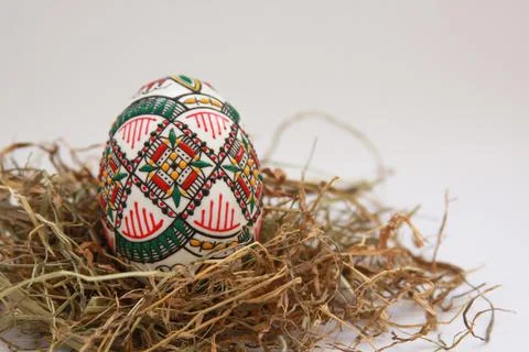 Traditional painted handmade Easter egg on hay Stock Photos