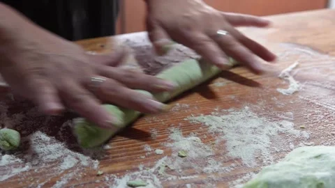 Traditional pasta making: cutting the green dough for individual gnocchi 库存影片 314092796