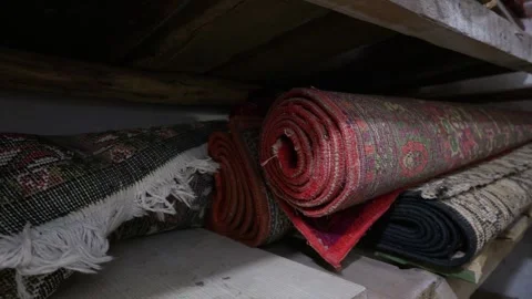 Traditional Patterned Carpets Rolled and Stacked on Wooden Storage Shelves Stock Footage 335644942