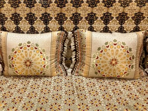 Traditional, patterned, Moroccan bedclothes with silk cushions Stock Photos