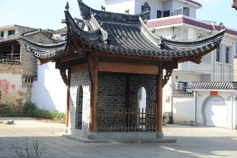 Traditional pavilion with dramatic curved tiled roof in open courtyard besi.. Stock Photos