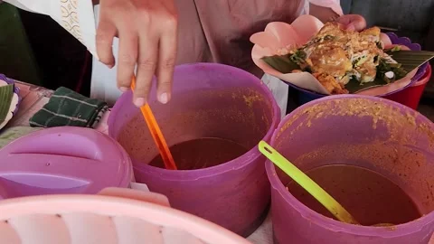 Traditional pecel, peanut sauce dish, vendor preparing delicious meal Stock Footage 330268623