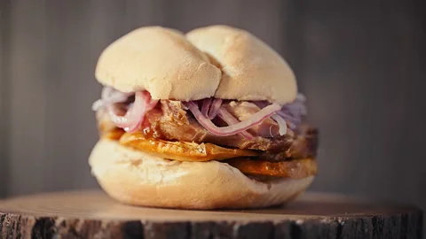 Traditional Peruvian Pan con Chicharron Pork Sandwich with Sweet Potato Stock-Footage 338341335